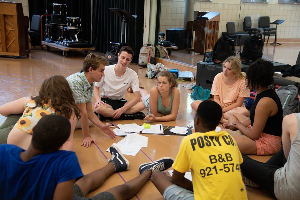 Beth Siegling (Sally Bowles, center) and her members of the 'Cabaret' ensemble dig into their scripts during rehearsal. Photo by Sarah Rolleri.